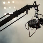 TV camera on a crane on football mach or concert